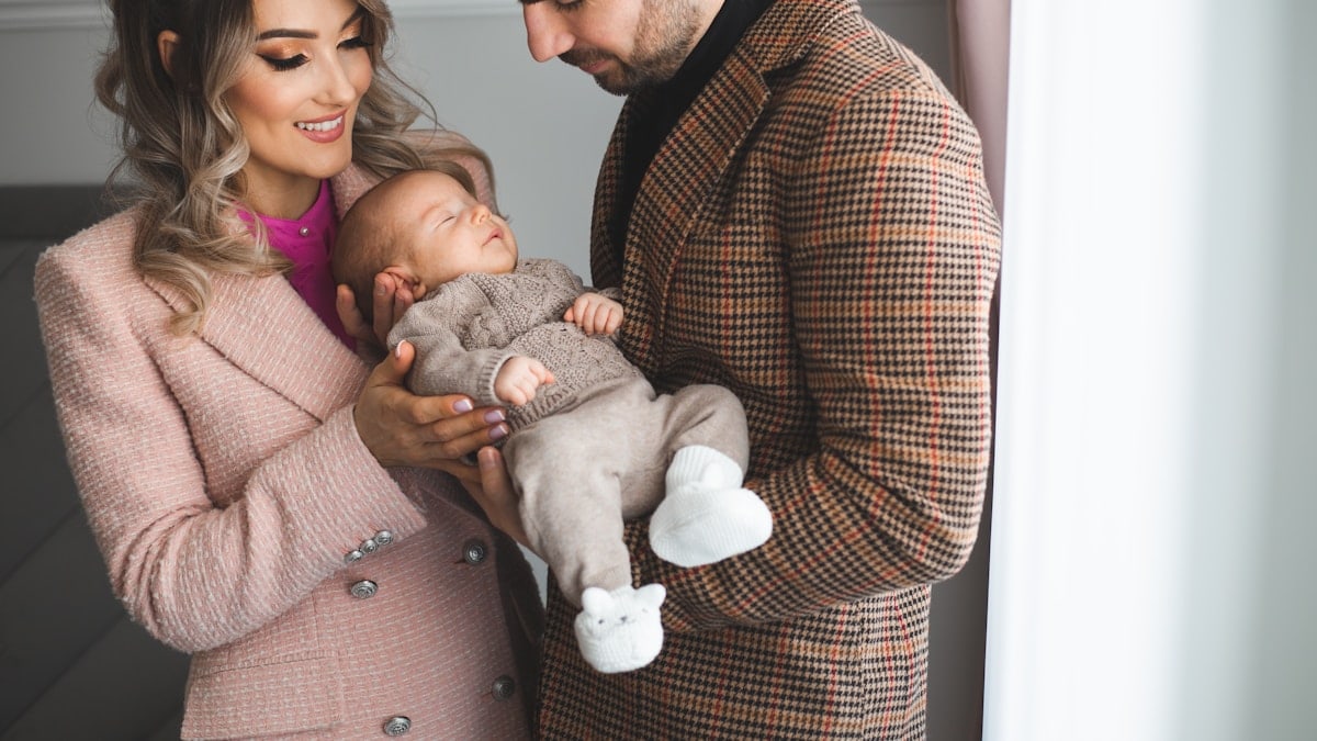 Mother and father holding their young baby boy in their hands.